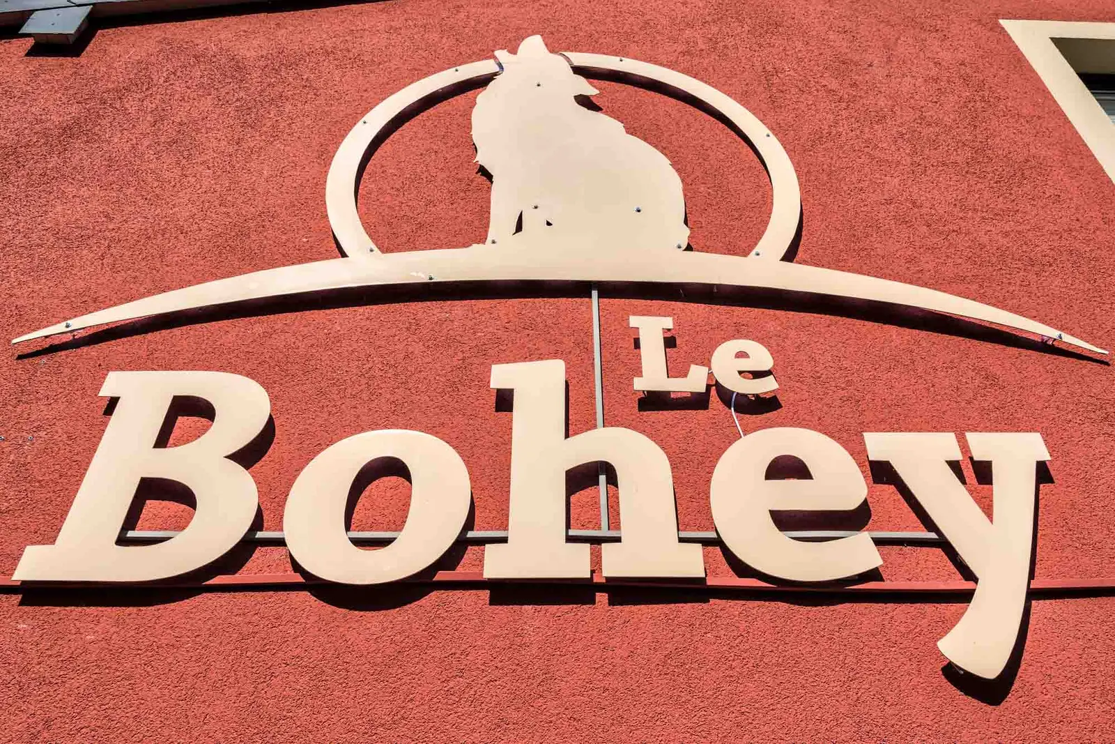 Het uithangbord van de Bohey met zijn wolf, op de rode gevel