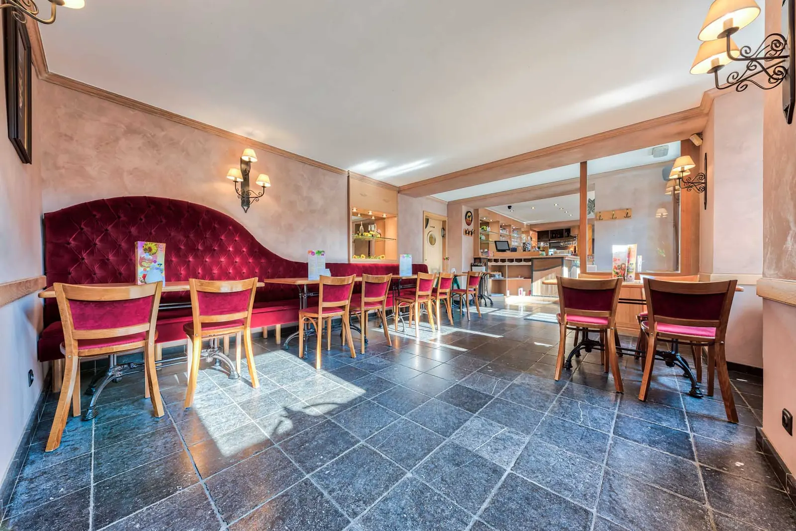 Une salle dressée, avec ses banquettes rouges